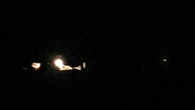 The tractor heading toward the field in the dark.